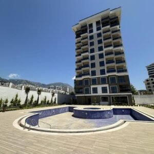 Просторная квартира формата 2+1 расположена в районе Махмутлар, Аланья, в современном жилом комплексе с развитой инфраструктурой.