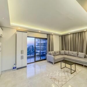 Квартира 1+1 на первой линии моря в Каргыджаке, Аланья — панорамный вид на море и горы.